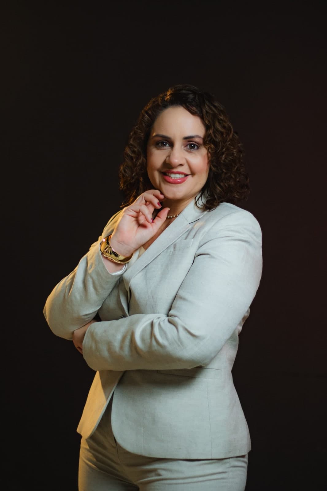 Camila Mota Figueiredo sorrindo, de blazer claro